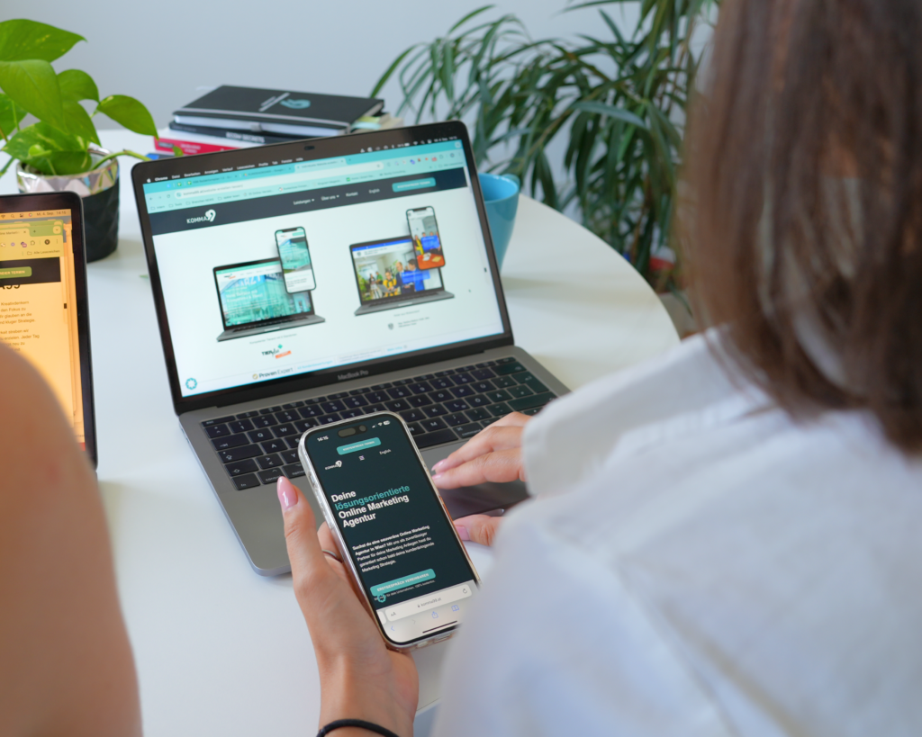 Person betrachtet Webseiten auf Desktop und Smartphone.