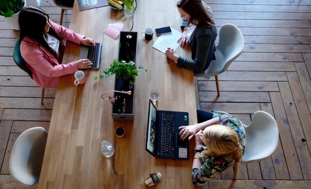 Employer Branding: Definition, Best Practices, Maßnahmen 1 Drei Personen arbeiten auf einem großen Arbeitstisch