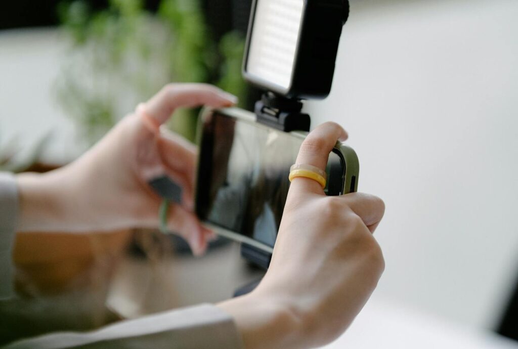Content Marketing einfach erklärt 3 Person stellt Handy Frontkamera ein, um zu filmen
