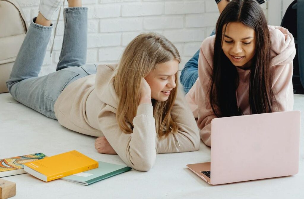 Generation Z und ihre Erwartungen an nachhaltige Markenkommunikation 1 Zwei Freundinnen sitzen am Boden und schauen in einen Laptop