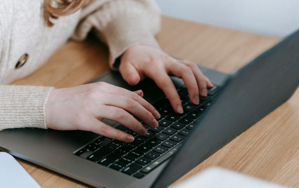 hände tippen auf der tastatur eines laptops auf einem tisch